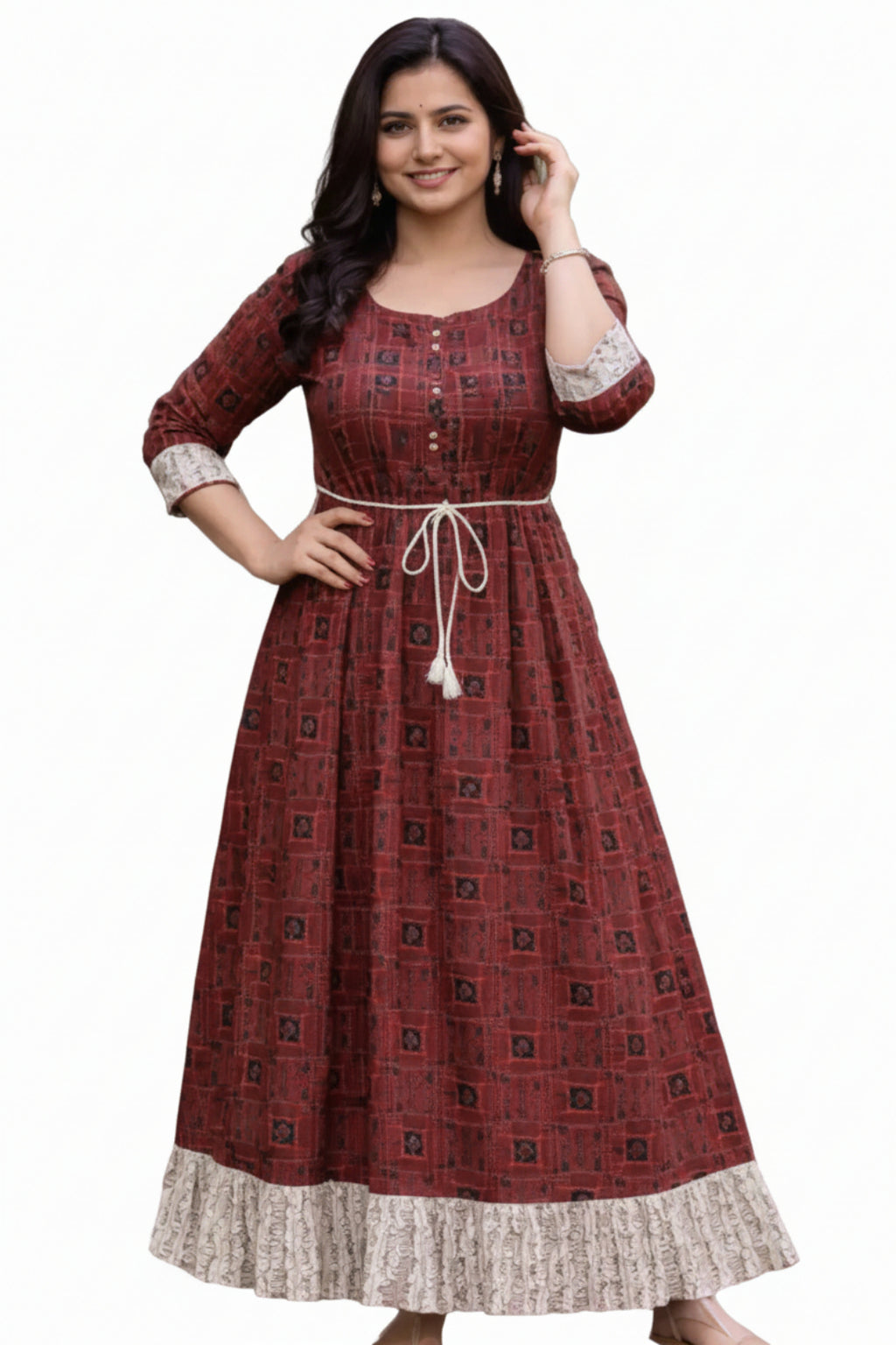 Woman wearing a patterned red dress standing outdoors on a wooden path.