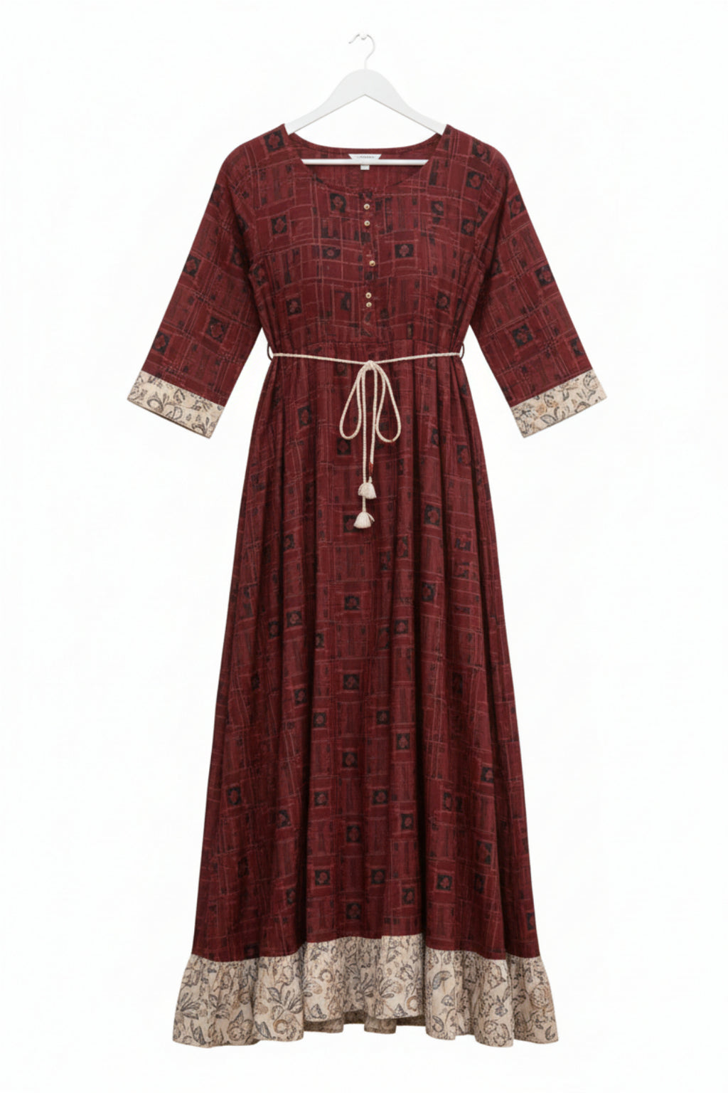 Woman wearing a maroon patterned dress on a white background