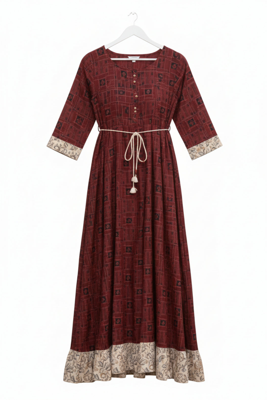 Woman wearing a maroon patterned dress on a white background