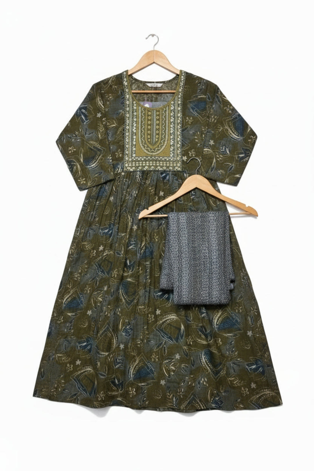 Green patterned dress with a matching mask on a white background