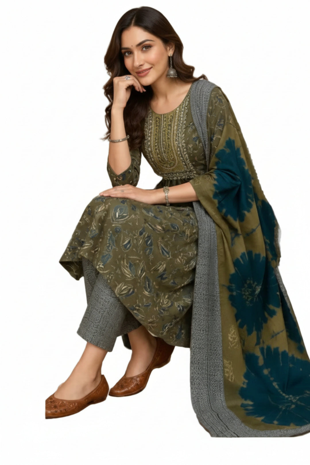 Woman in traditional outfit with a floral patterned dupatta, sitting indoors.