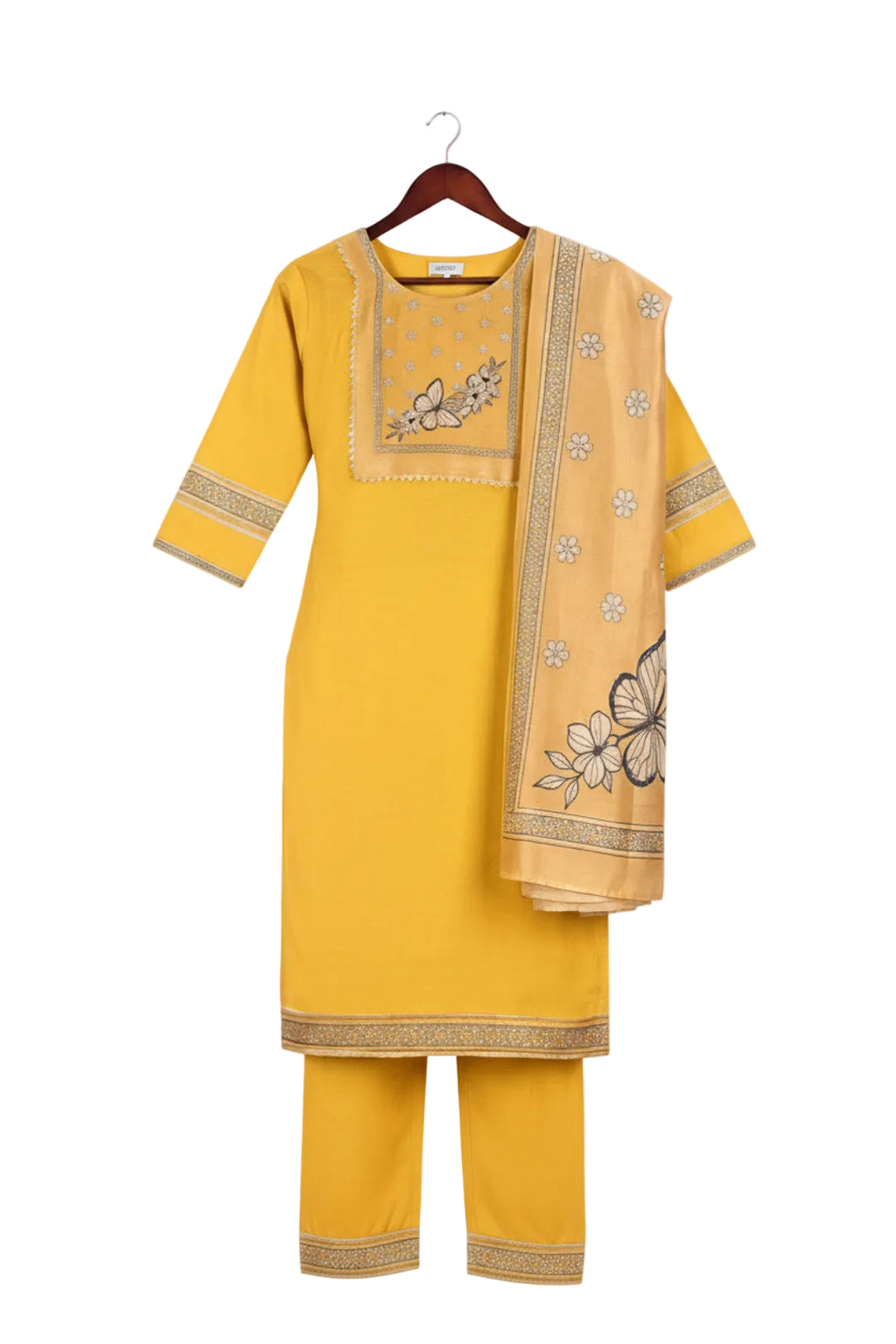 Woman wearing a yellow traditional outfit with intricate designs, posing against a light background.