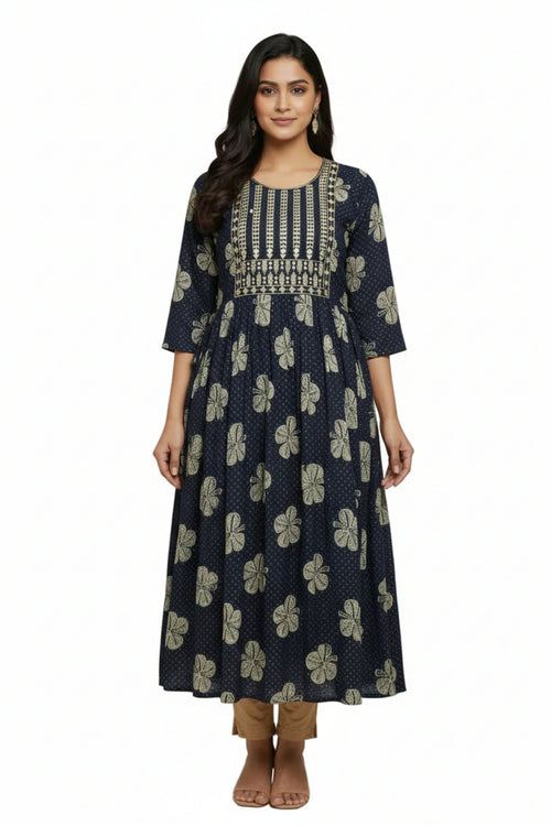 Woman wearing a navy blue floral dress with intricate patterns on a plain background