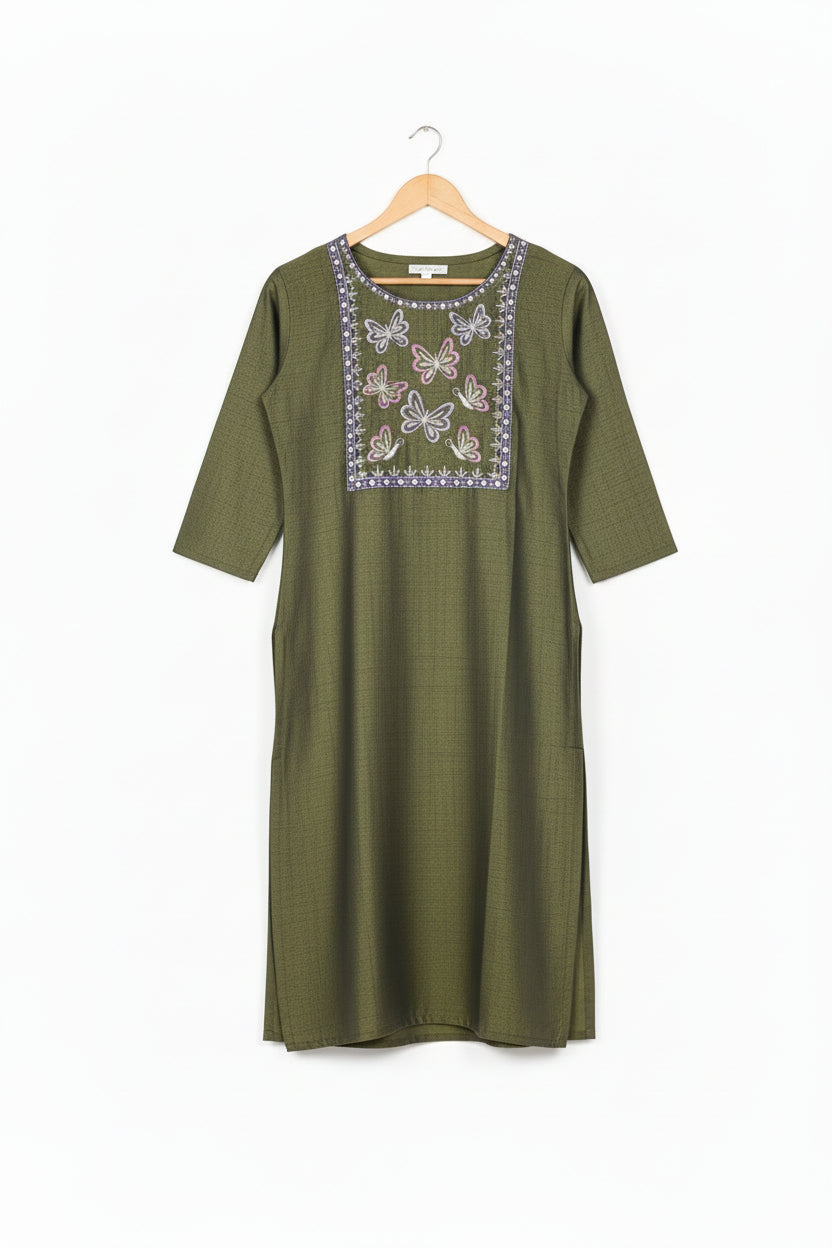 Woman wearing a green embroidered kurta with purple leggings on a white background