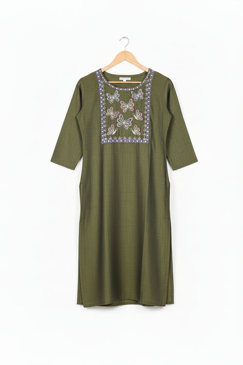 Woman wearing a green embroidered kurta with purple leggings on a white background