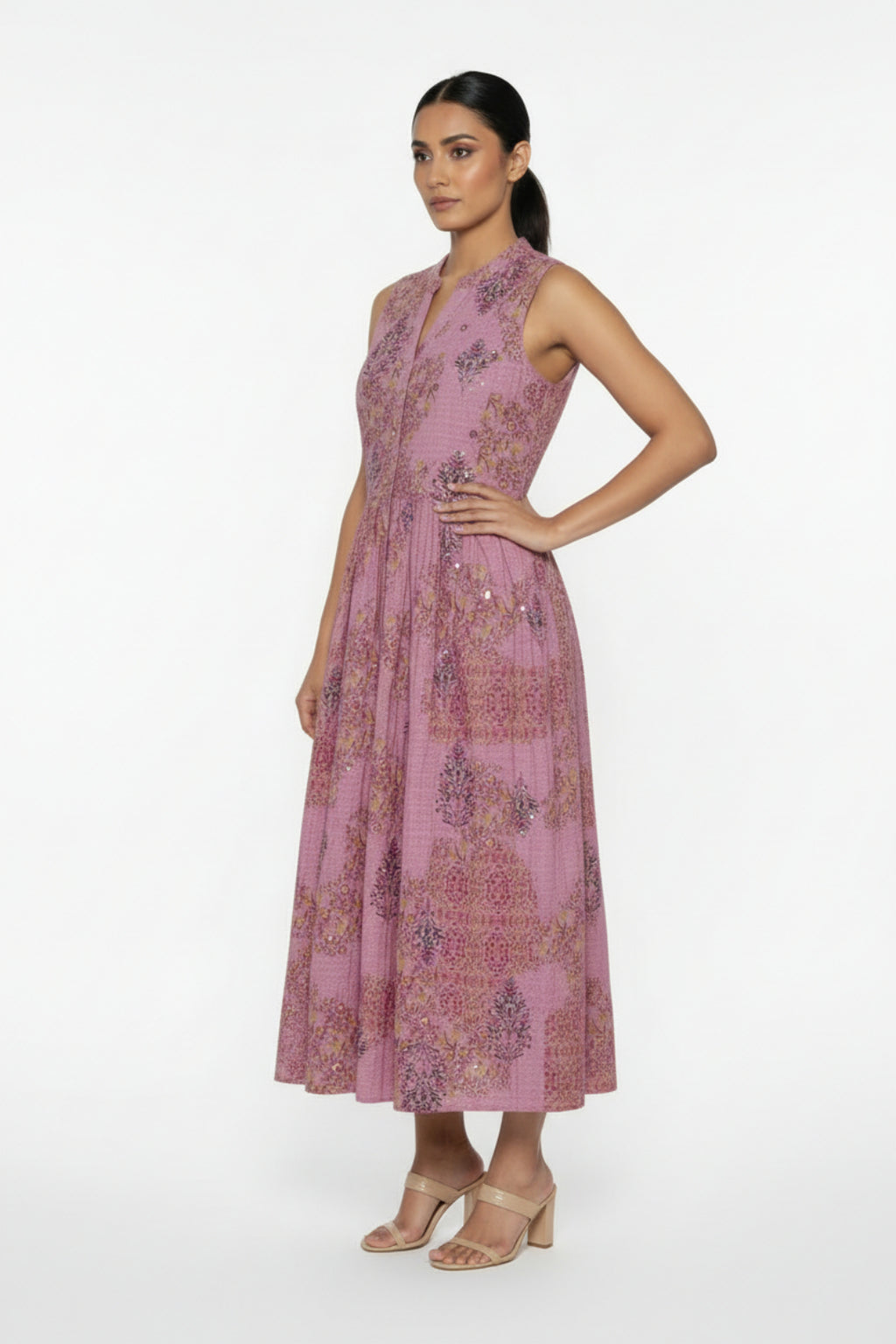 Pink floral dress on a white surface with a blue flower decoration.