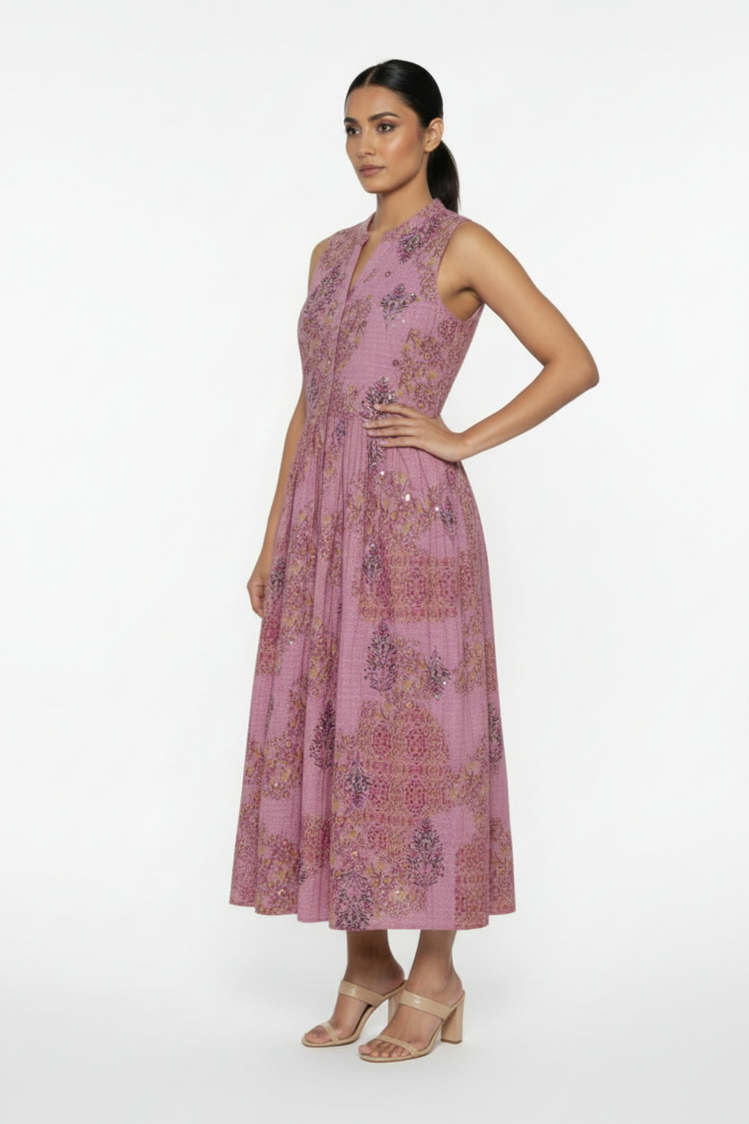 Pink floral dress on a white surface with a blue flower decoration.