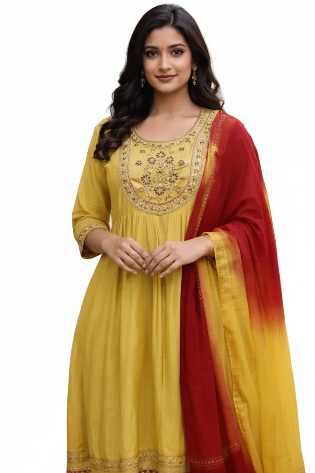 Woman wearing a yellow embroidered outfit with a red and yellow dupatta outdoors.