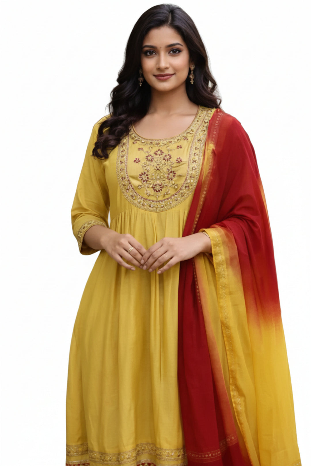 Woman wearing a yellow embroidered outfit with a red and yellow dupatta outdoors.