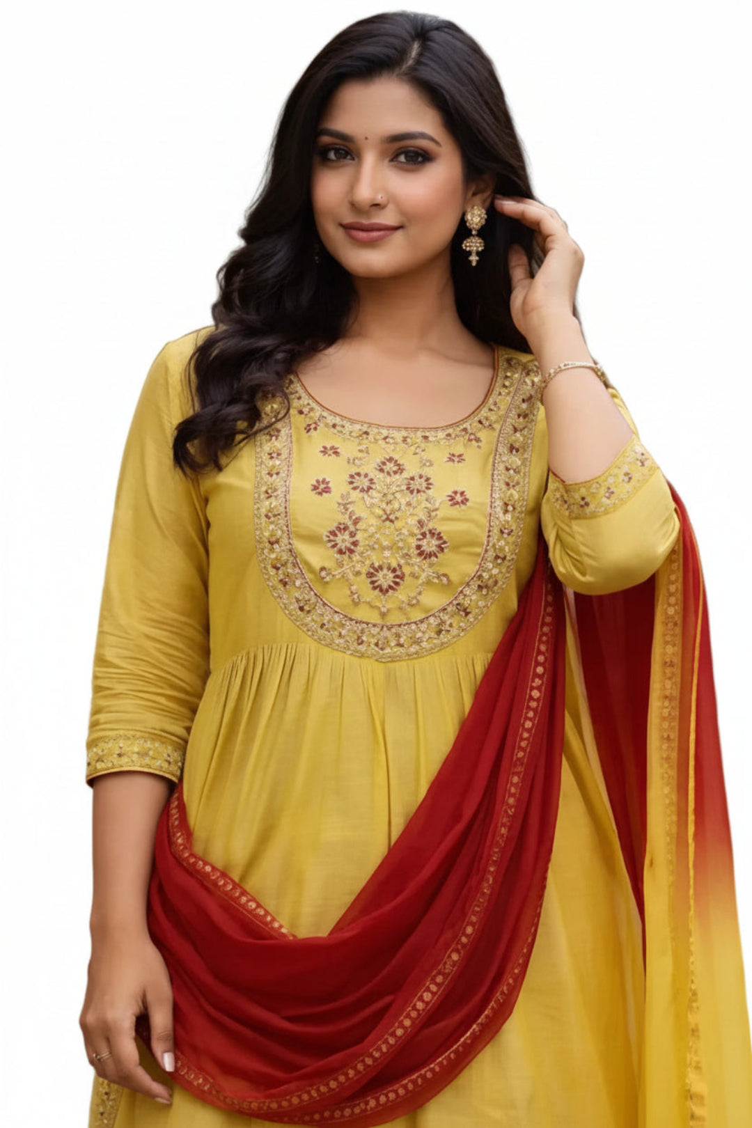Woman wearing a yellow and red traditional outfit with embroidery, standing outdoors.